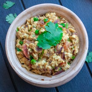 Indian style Scrambled tofu curry in a serving pot garnished with cilantro on top