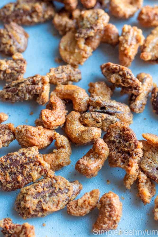 Candied cashews and pecans spread on a white surface