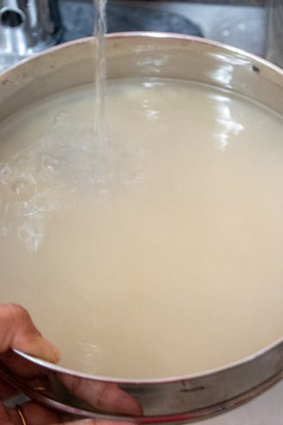 Rinsing rice under tap water