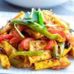 Close up image of Paneer Jalfrezi on a white plate with cilantro garnished on top