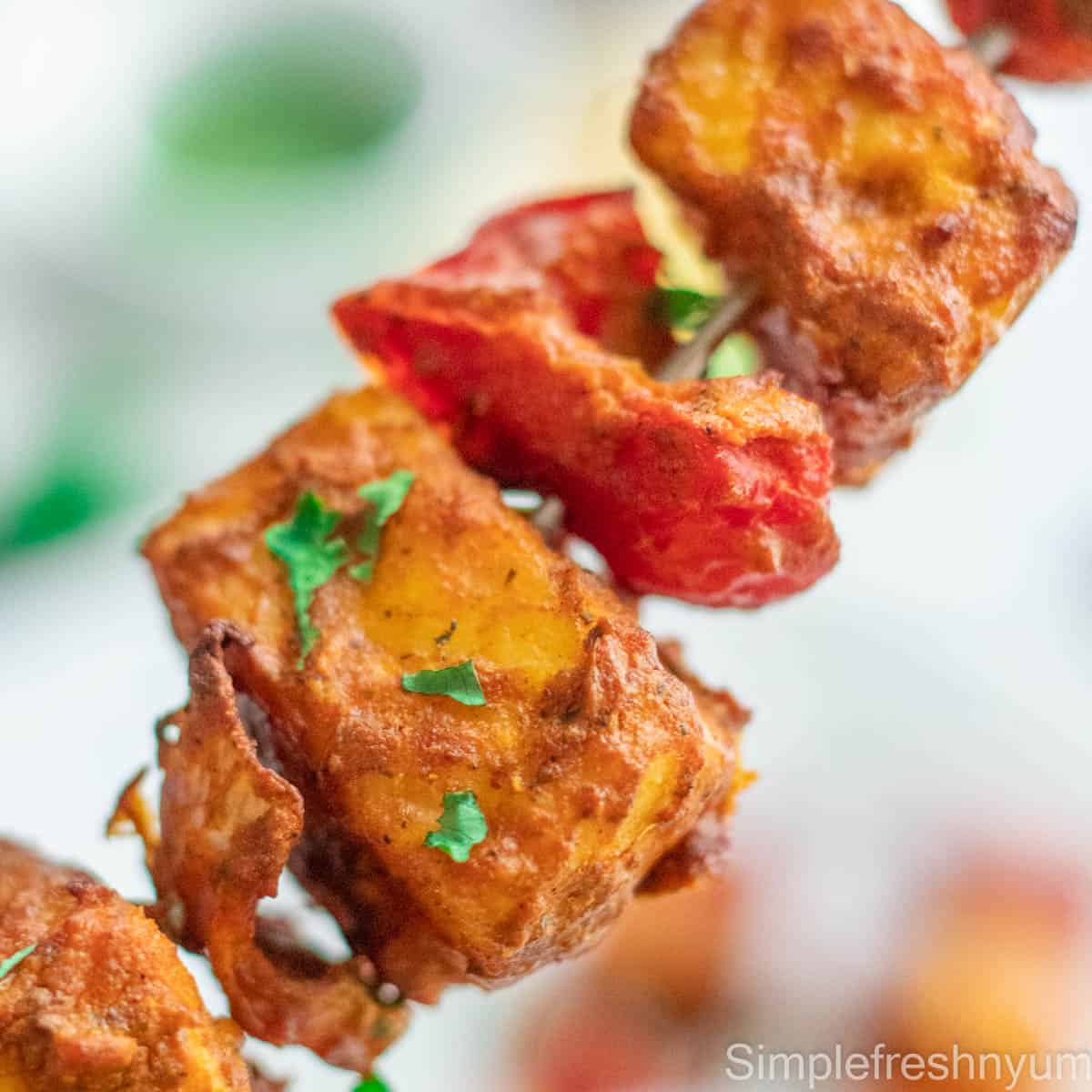 Air fryer grilled paneer and bell peppers on a skewer with cilantro on top.