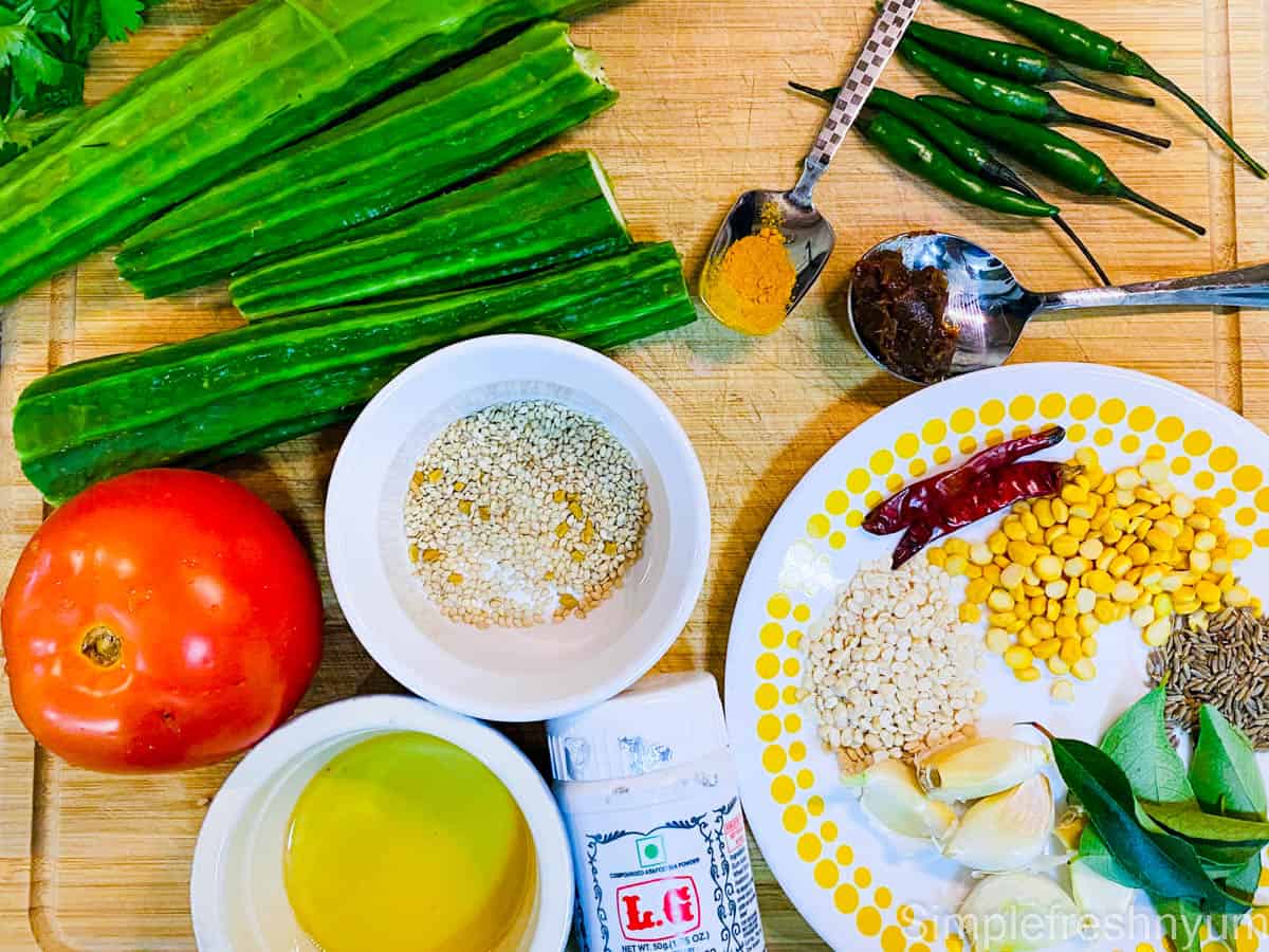 Ingredients needed for making beerakaya pachadi laid out on a wooden chopping board.