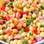 Indian chickpea salad served with lemon wedge in a white round plate.