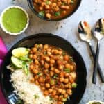 Instant pot Chole served with white rice in a black plate.